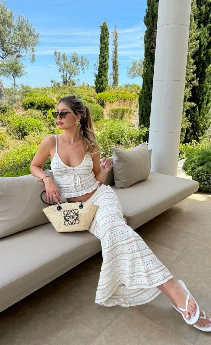 White crochet top and skirt paired with a LOEWE straw bag